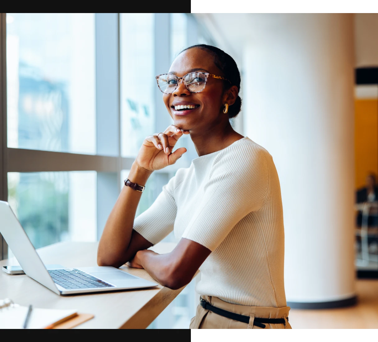 Woman smiling at desk with laptop